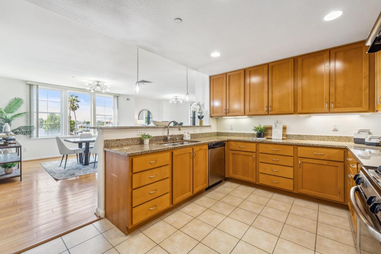 1388 Broadway, Unit 209 Millbrae, CA 94030 - Photo 8 of 40 a kitchen with stainless steel appliances granite countertop a stove top oven a sink dishwasher and cabinets with granite countertops