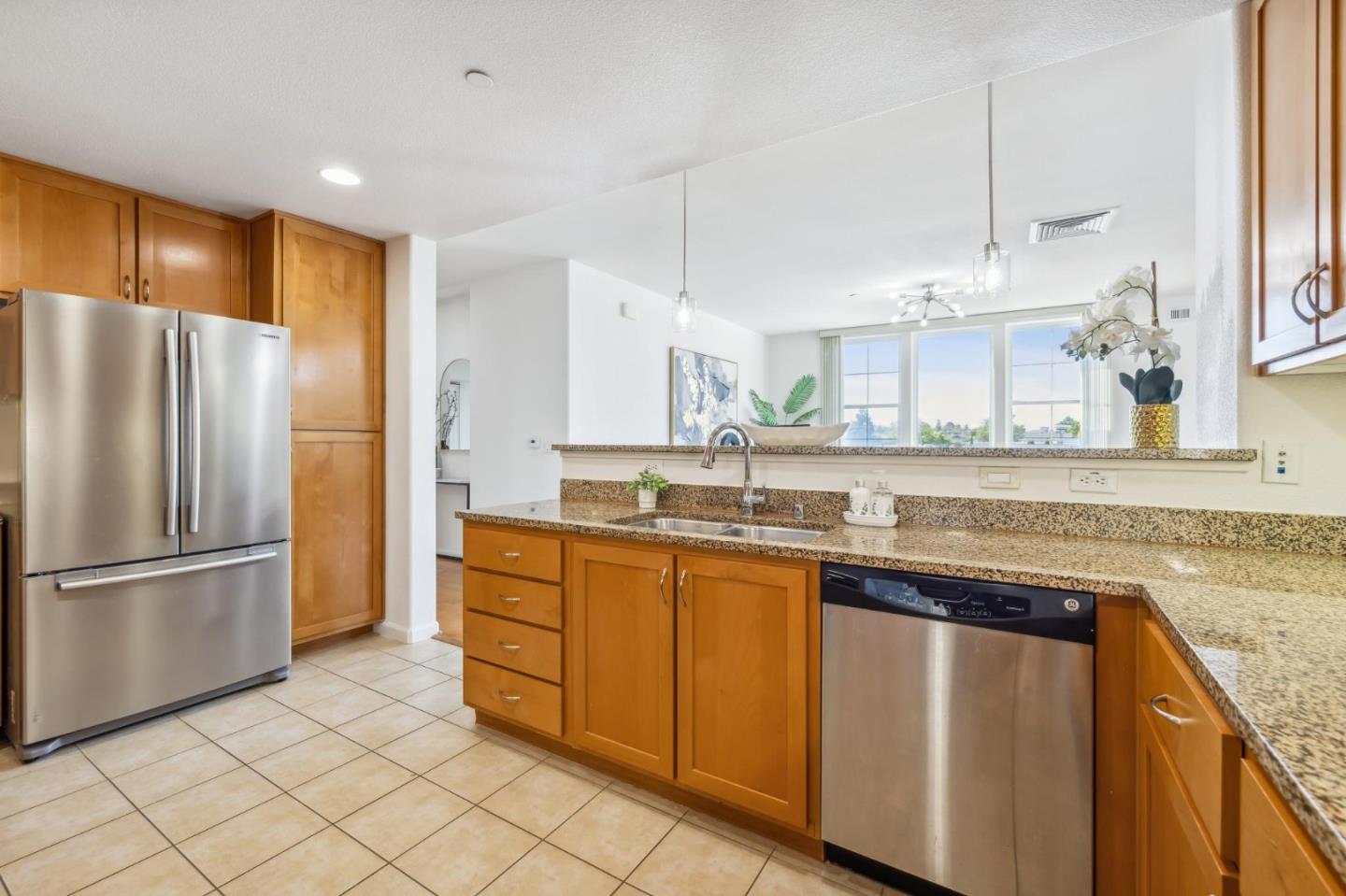 1388 Broadway, Unit 209 Millbrae, CA 94030 - Photo 10 of 40 a kitchen with stainless steel appliances granite countertop a refrigerator a sink dishwasher and a fireplace