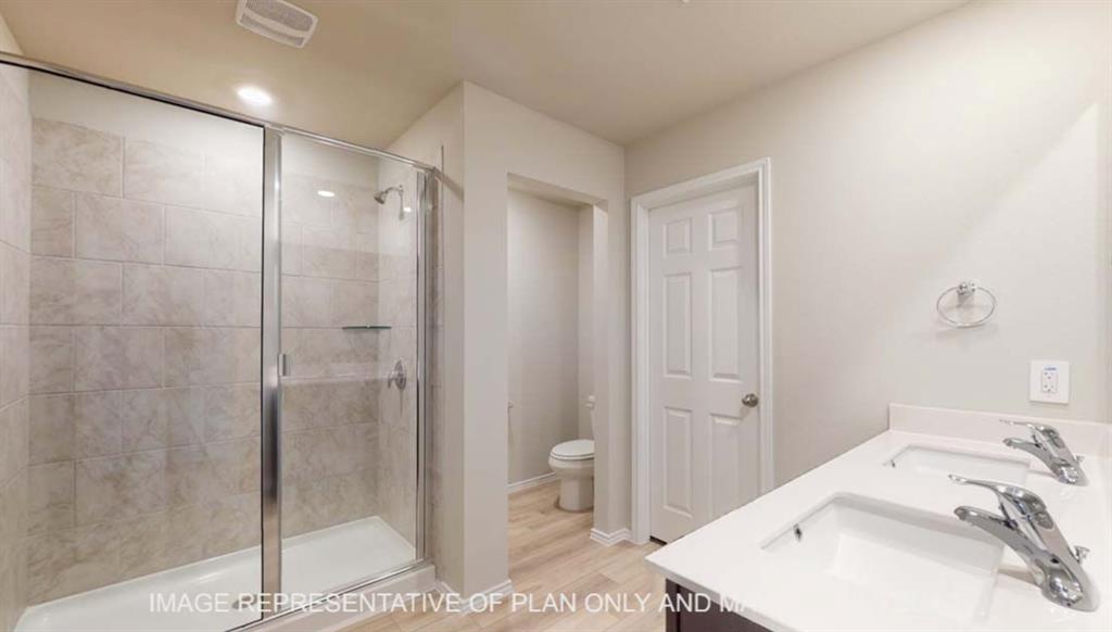 10429 Neptune Court Waco, TX 76708 - Photo 10 of 16 Dual rectangular undermount sinks, spacious countertop, wood-finish flooring, glass-enclosed shower with tile surround, and recessed lighting