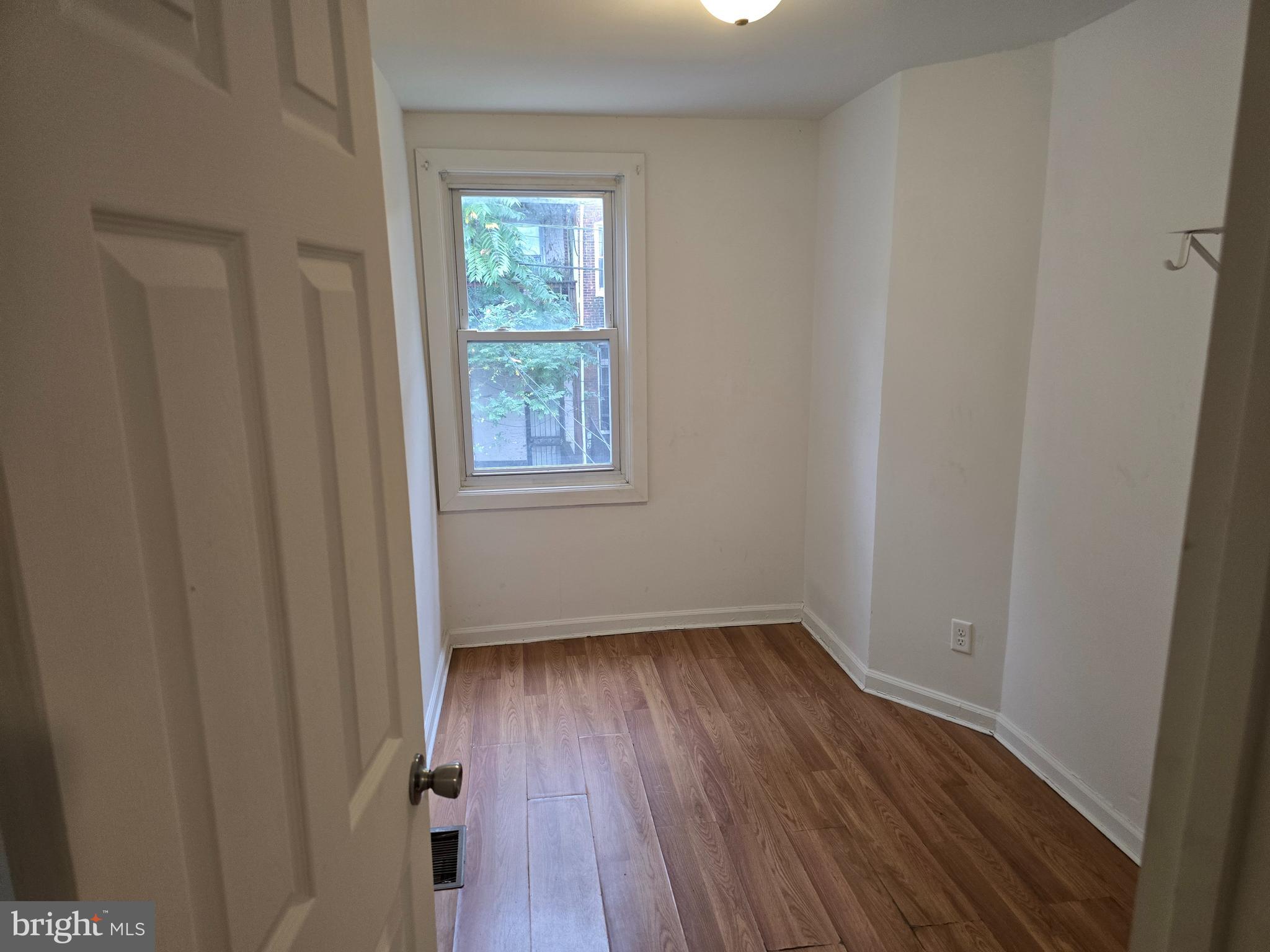 2418 Etting Street Baltimore, MD 21217 - Photo 17 of 24 a view of an empty room with wooden floor and a window