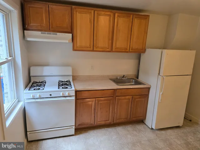 a kitchen with stainless steel appliances granite countertop a refrigerator a stove a sink and dishwasher