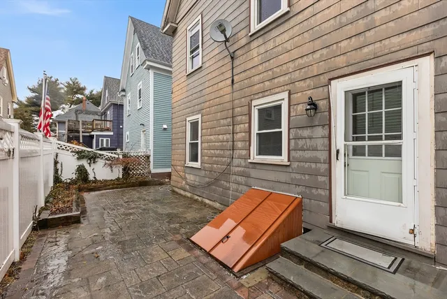 a backyard of a house with barbeque oven table and chairs