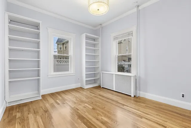 a view of an empty room with a cabinet and a window