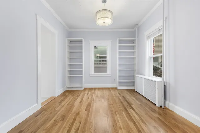 a view of a room with wooden floors and window