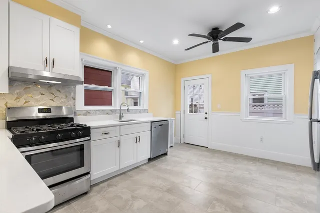 a kitchen with stainless steel appliances a stove sink and cabinets