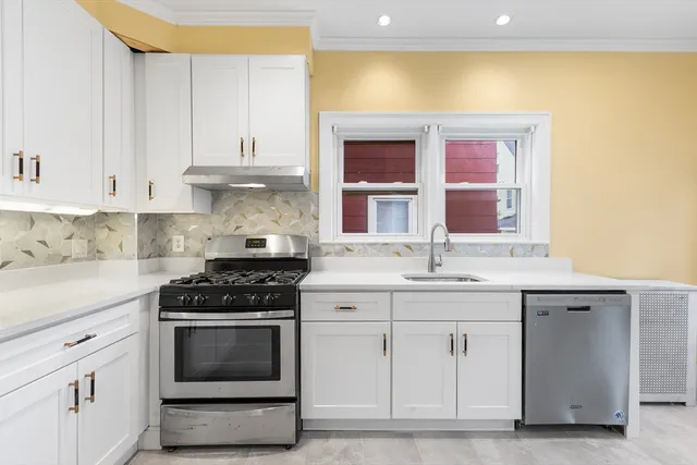 a kitchen with granite countertop a sink stainless steel appliances and cabinets