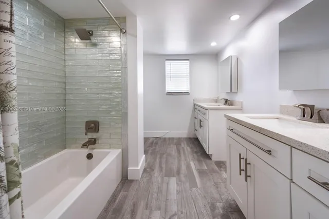 a bathroom with a tub sink and mirror
