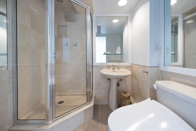 a bathroom with a sink toilet and shower