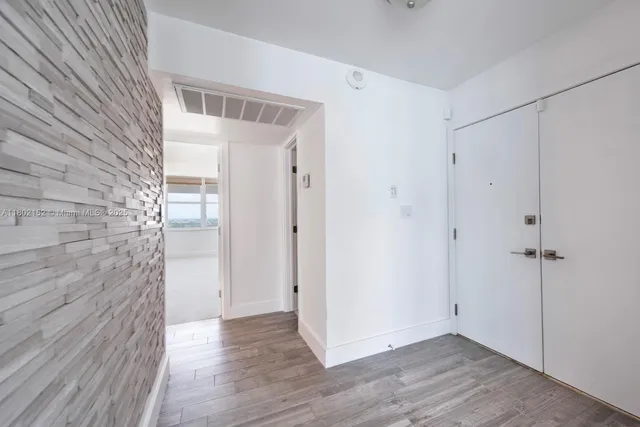 a view of an empty room with wooden floor