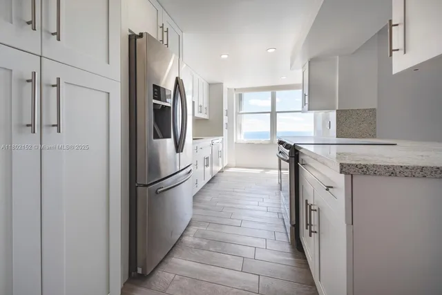 a kitchen with stainless steel appliances granite countertop a refrigerator and a stove