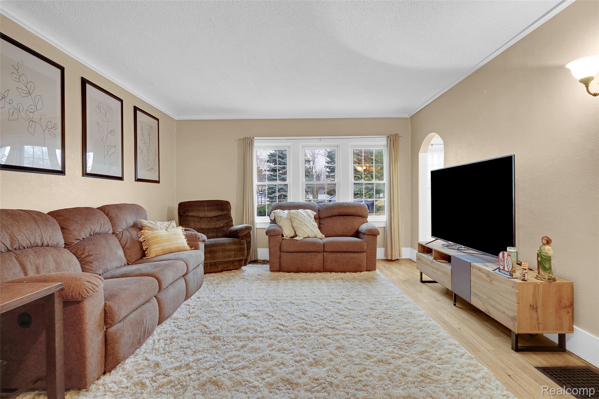 7972 3rd Street Forestville, MI 48434 - Photo 13 of 35 Living room with light wood-style flooring, ornamental molding, and a textured ceiling