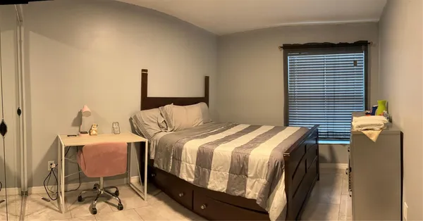 a bedroom with a bed and dresser with mirror