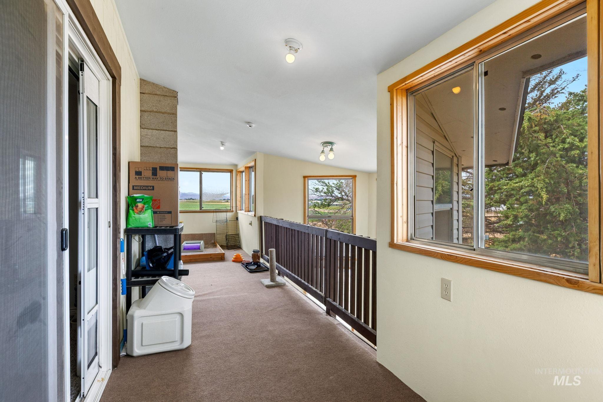 18338 Pride Lane Caldwell, ID 83607 - Photo 27 of 50 Carpeted hallway with wood-frame windows and a wood railing overlooking a lower space