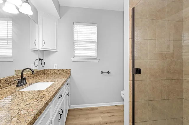 a bathroom with a granite countertop sink a mirror and vanity