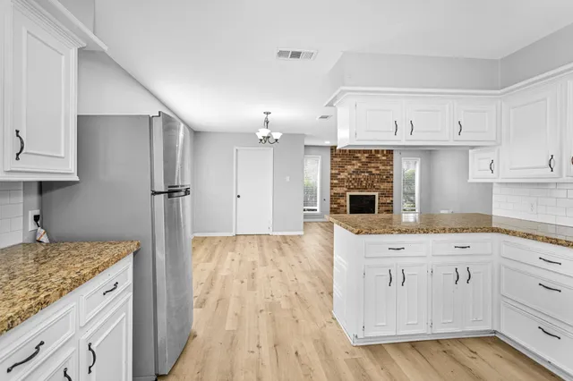 a kitchen with kitchen island granite countertop a sink and refrigerator