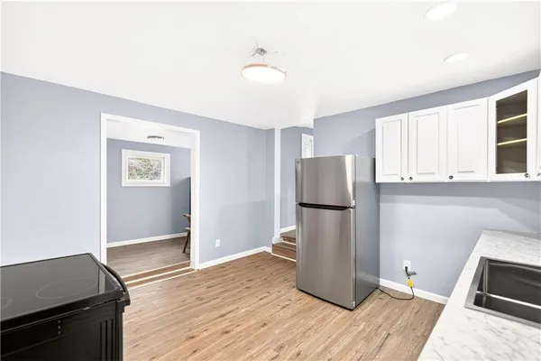 a kitchen with a refrigerator and a stove top oven