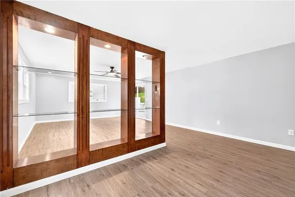 a view of an empty room with wooden floor and windows
