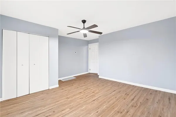 a view of a room with wooden floor and a ceiling fan