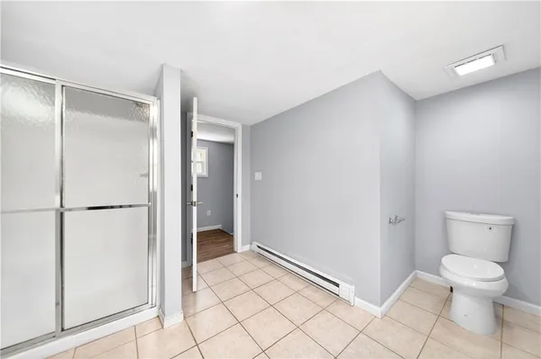 a bathroom with a toilet and a shower