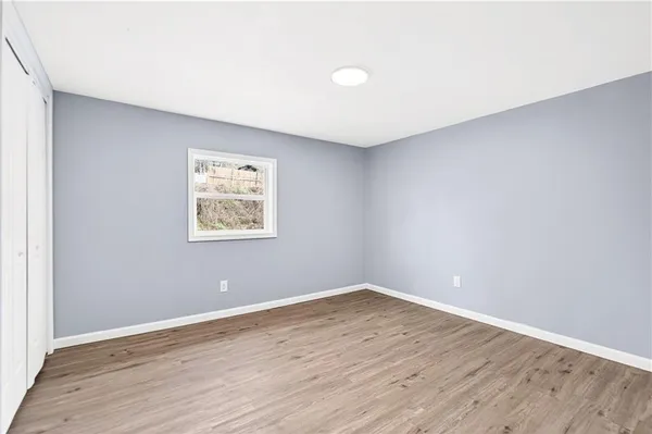 a view of an empty room with wooden floor