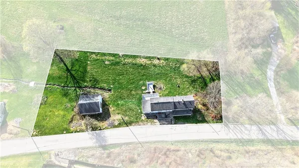 an aerial view of residential houses with outdoor space and trees