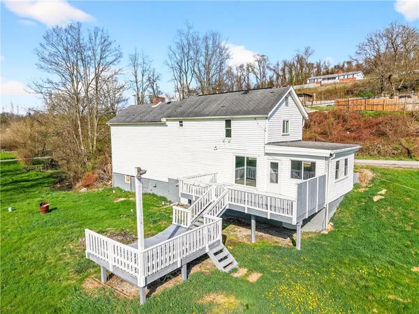 a view of a house with a yard and deck