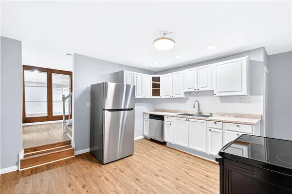 a kitchen with stainless steel appliances a refrigerator sink and cabinets