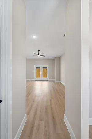 a view of an empty room with wooden floor and a window