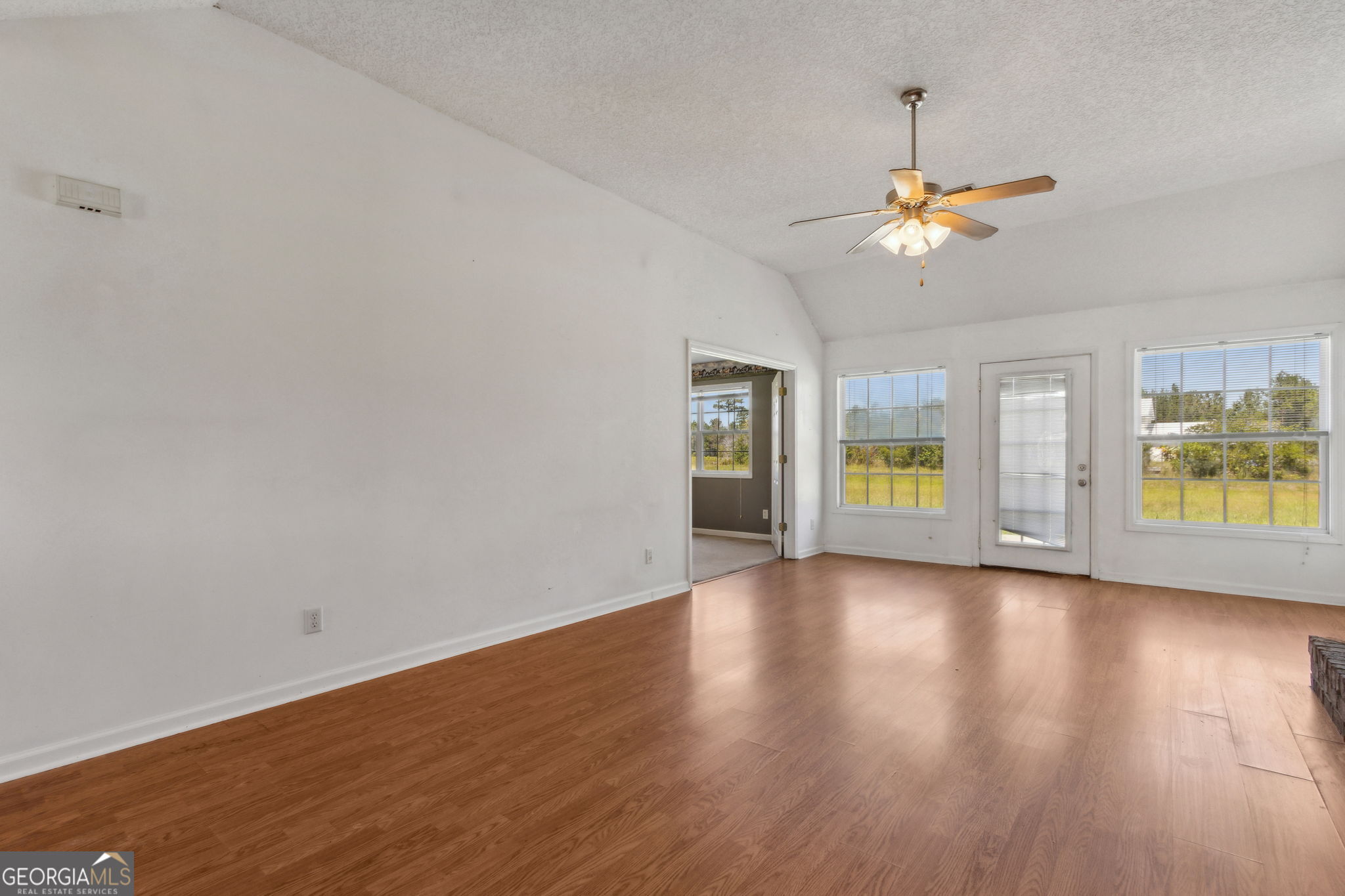77 Thoroughbred Road Woodbine, GA 31569 - Photo 12 of 73 a view of an empty room with a window and wooden floor