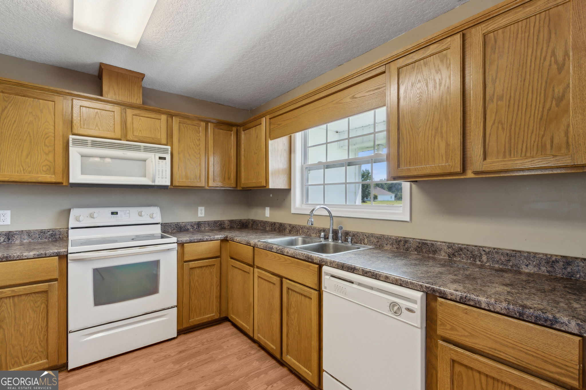 77 Thoroughbred Road Woodbine, GA 31569 - Photo 24 of 73 a kitchen with stainless steel appliances granite countertop a sink stove and microwave