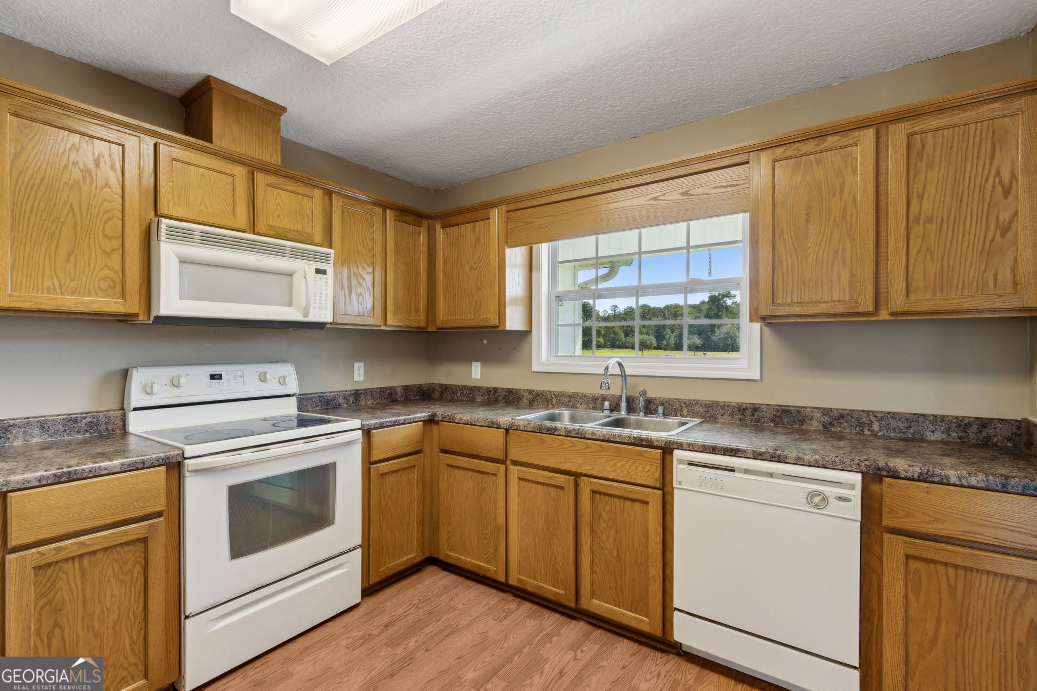 77 Thoroughbred Road Woodbine, GA 31569 - Photo 29 of 73 a kitchen with stainless steel appliances granite countertop white cabinets sink and window