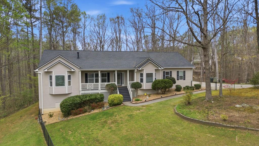 a front view of house with yard and trees in the background