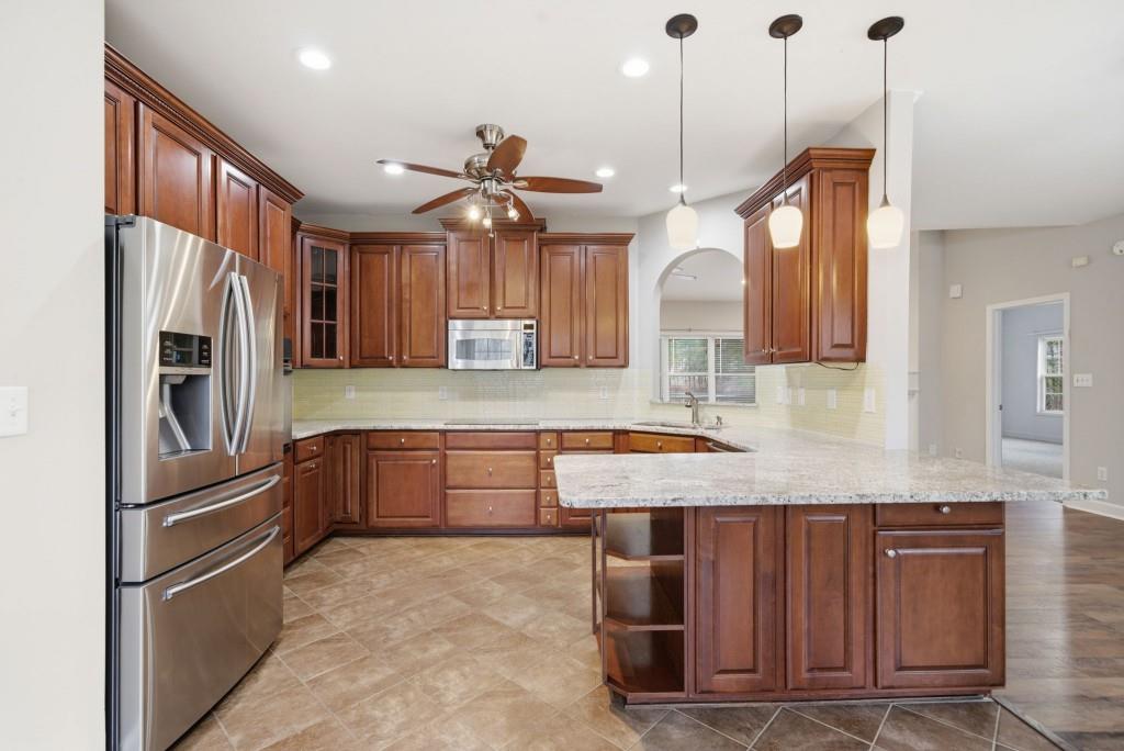 42 Nate Trail Dallas, GA 30157 - Photo 19 of 67 a kitchen with granite countertop a refrigerator a sink and wooden floor