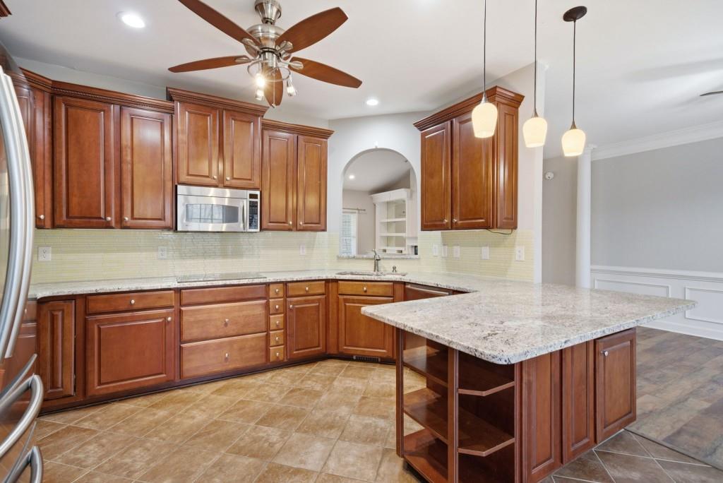 42 Nate Trail Dallas, GA 30157 - Photo 20 of 67 a kitchen with kitchen island granite countertop wooden cabinets a dining table and chairs