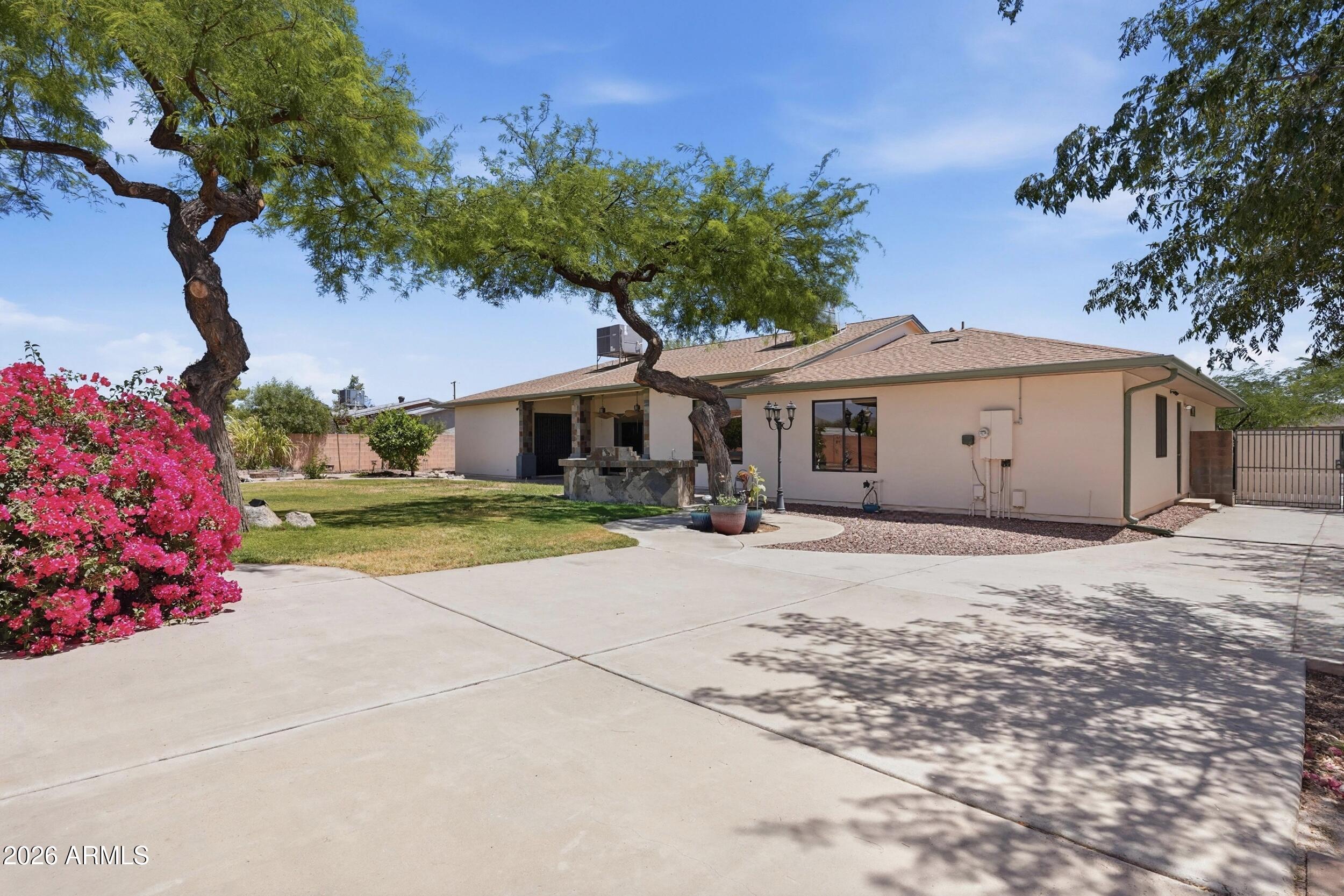 6334 East Albany Street Mesa, AZ 85205 - Photo 2 of 72 a front view of a house with a yard and garage