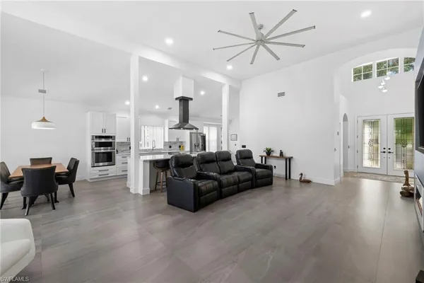 a living room with furniture and a view of kitchen