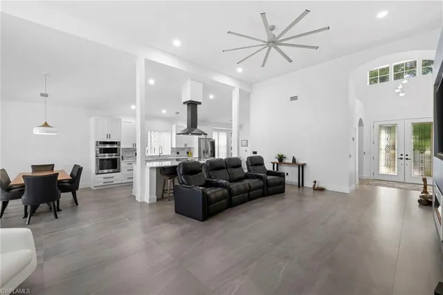 a living room with furniture and a view of kitchen