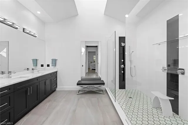 a bathroom with a double vanity sink a mirror and a shower