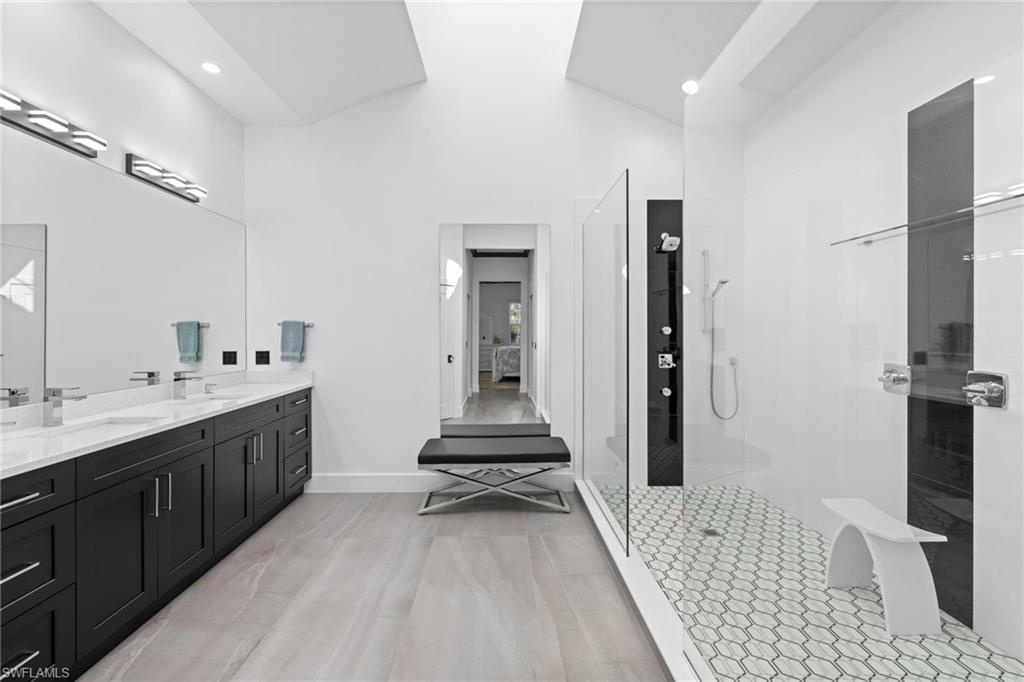 6903 Mauna Loa Lane Naples, FL 34113 - Photo 26 of 46 a bathroom with a double vanity sink a mirror and a shower