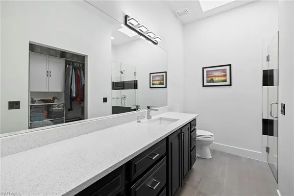 a spacious bathroom with a sink a toilet and mirror