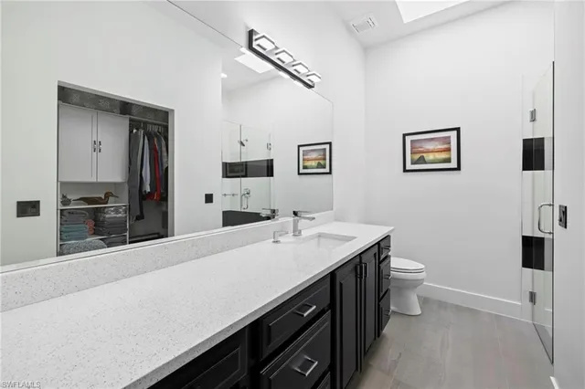 a spacious bathroom with a sink a toilet and mirror