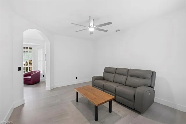 a living room with furniture and a ceiling fan