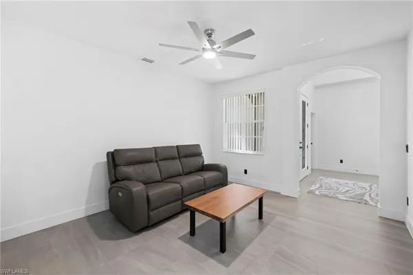 a living room with furniture and a ceiling fan