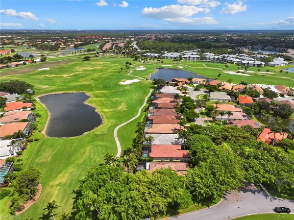 an aerial view of a houses with a yard and lake view