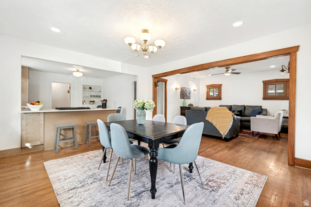 4883 South Center Street Murray, UT 84107 - Photo 2 of 32 Dining area featuring wood-finish flooring and a central chandelier
