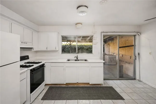 a kitchen with a sink a refrigerator and cabinets