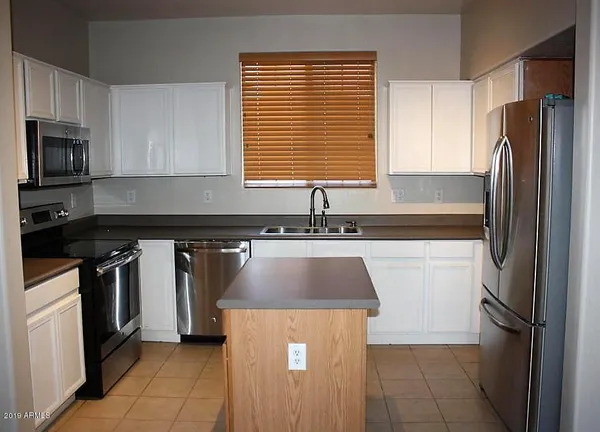 a kitchen with granite countertop a refrigerator and a sink