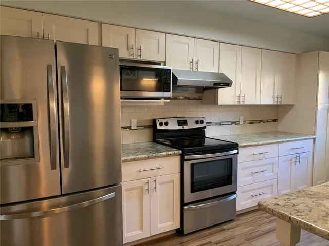 a kitchen with stainless steel appliances a refrigerator stove and microwave