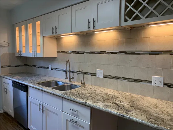 a kitchen with granite countertop a sink and a stove