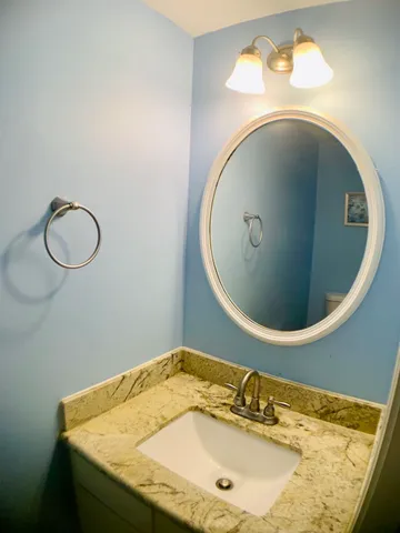 a bathroom with a granite countertop sink and mirror